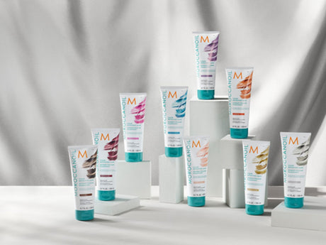 Assortment of hair care products displayed against a draped backdrop.