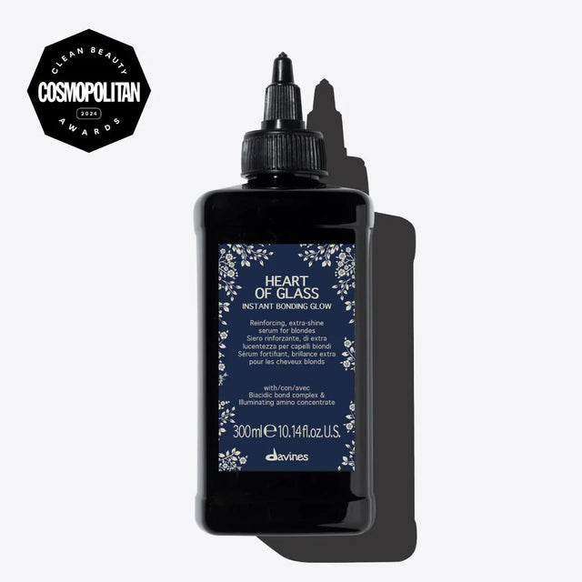 Heart of Glass Instant Bonding Glow serum bottle with award badge, enhances blonde hair shine and strength with Biacidic bond complex.