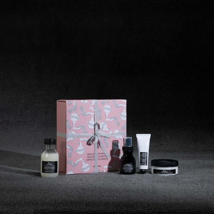 Davines Oi Travel Gift Set with shampoo, conditioner, all-in-one milk, and hand balm for hair care and skin hydration.
