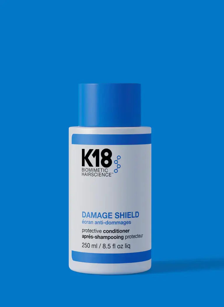 DAMAGE SHIELD Protective Conditioner bottle against a blue background showcasing hair care solution for damage protection and shine.