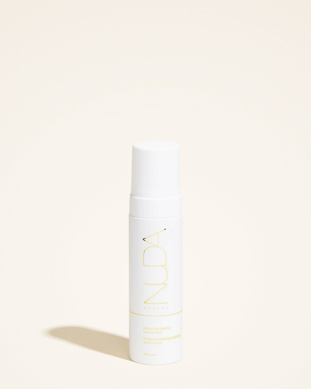 Bottle of Sunless Tan Remover exfoliating mousse with nourishing ingredients like Aloe Vera, white tea, and lemon extract for fresh skin.