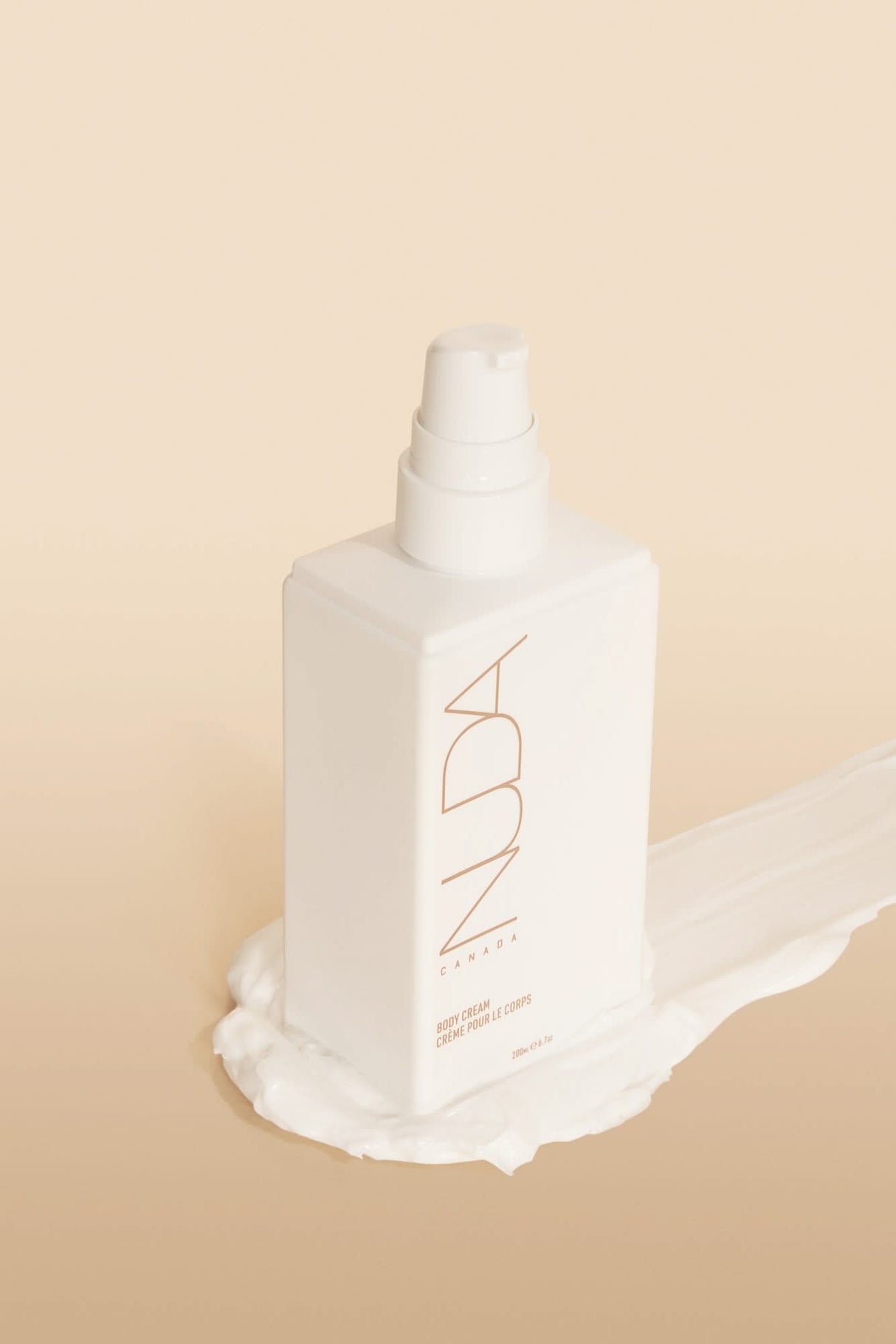 Nuda Routine Kit bottle on creamy backdrop, featuring self tanning mousse and skincare essentials for a radiant, seamless glow.