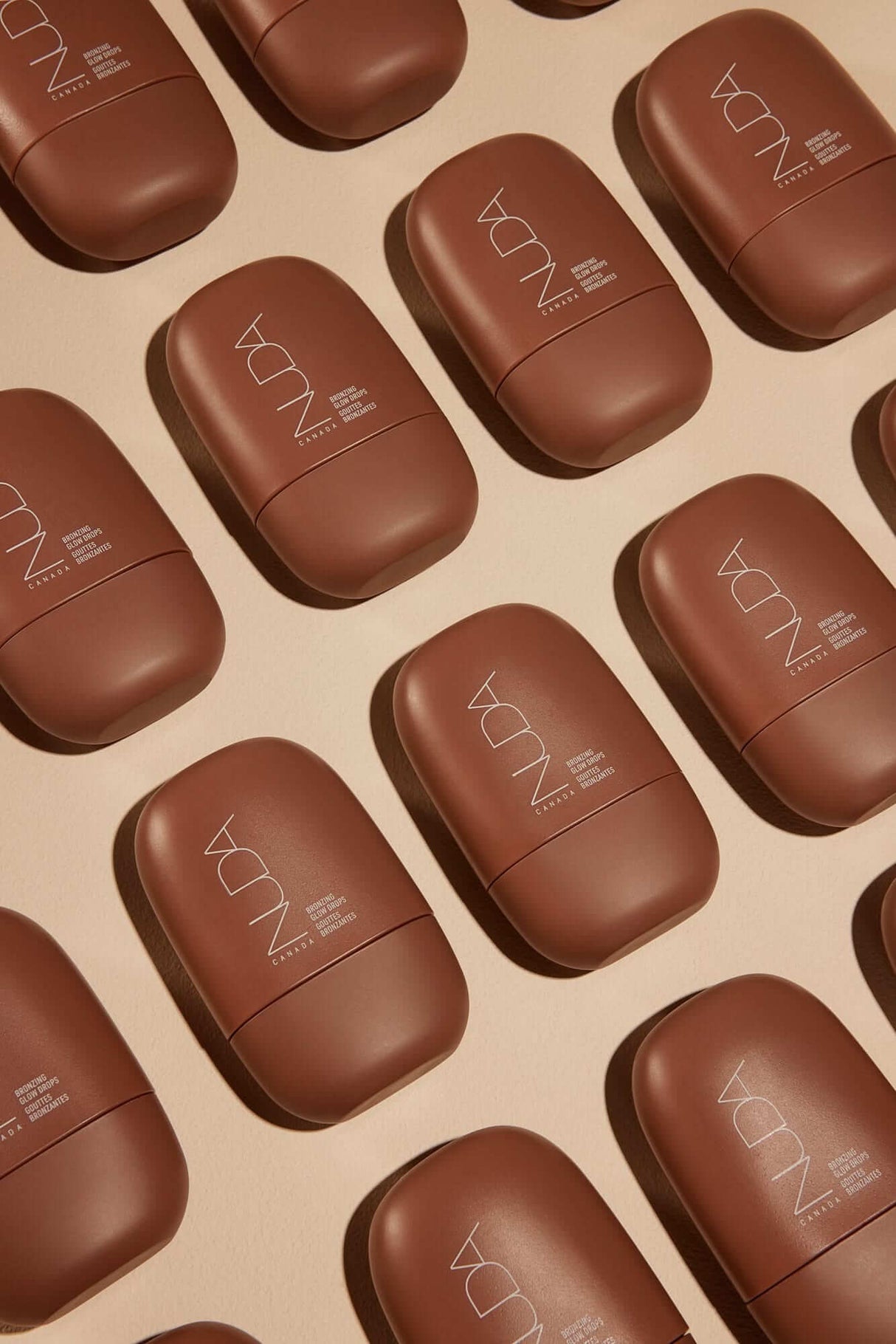 Self-tanning mousse bottles arranged in a pattern, highlighting premium skincare products for a radiant glow and bronzed look.