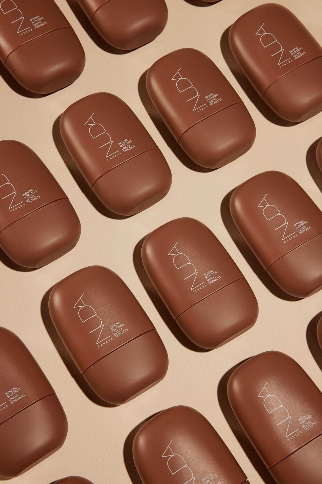 Self-tanning mousse bottles arranged in a pattern, highlighting premium skincare products for a radiant glow and bronzed look.