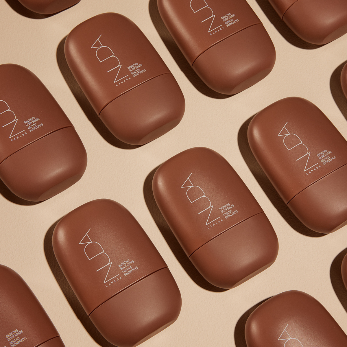Nuda Bronzing Glow Drops bottles arranged on a neutral background, showcasing the lightweight, hydrating liquid bronzer packaging.