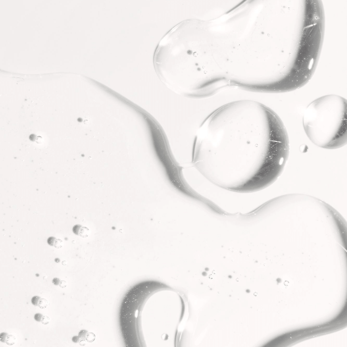 Close-up of a clear hyaluronic acid serum texture, showcasing smooth, hydrating properties for skincare and tanning applications.