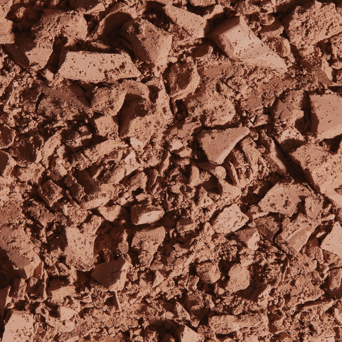 Crushed matte bronzing powder texture with natural tan and radiant glow for makeup application.
