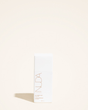 Self tanning lotion bottle on a beige background, promising hydration and a lasting radiant glow for light to medium skin tones.