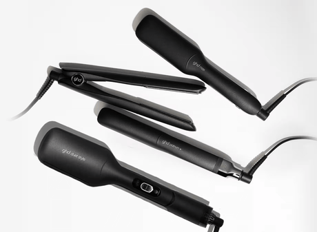 Black hair straighteners on a white surface, showing sleek design and features.