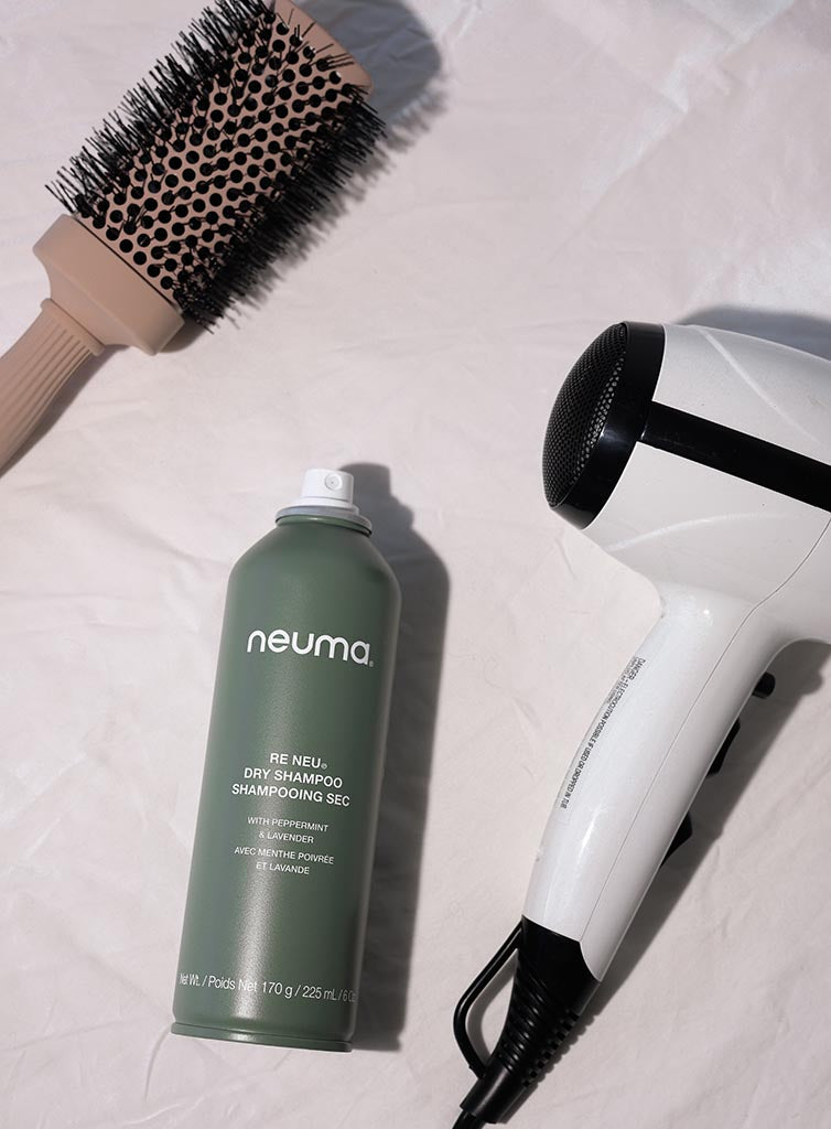 Re Neu Dry Shampoo with hairbrush and hairdryer on white background, ideal for adding volume and absorbing oils without washing.