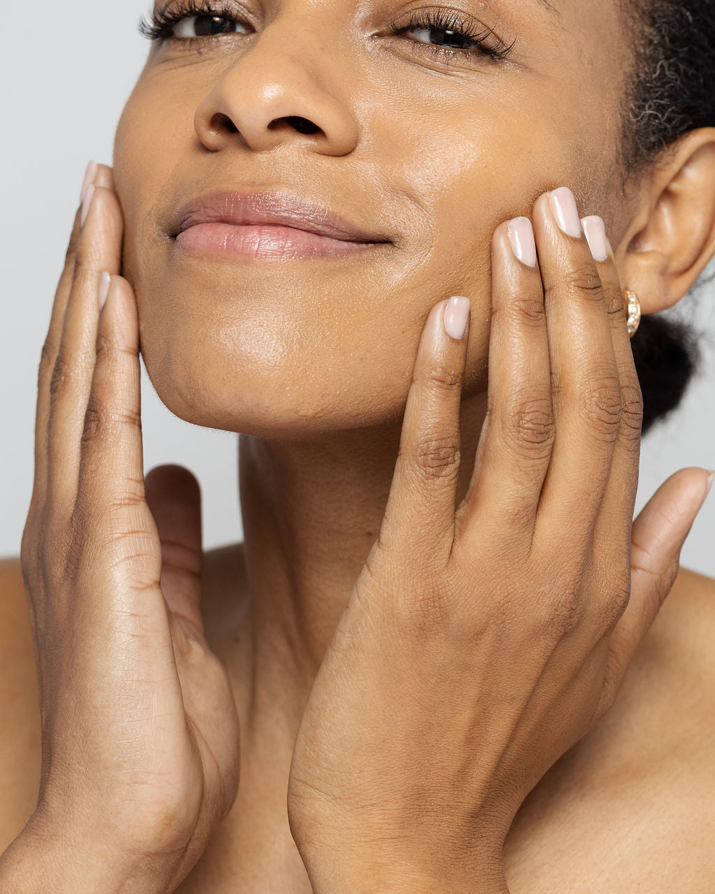Woman applying advanced skin lightening serum to reduce dark spots and wrinkles, showcasing smooth, radiant complexion.
