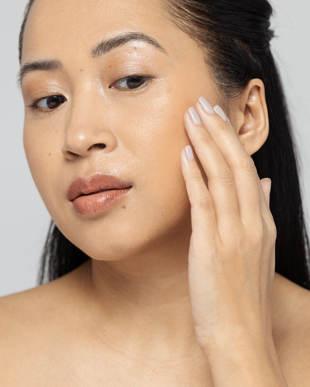 Woman applying Vivier Radiance Serum to face for improved tone and texture with natural ingredients like Arbutin and Vitamin C.