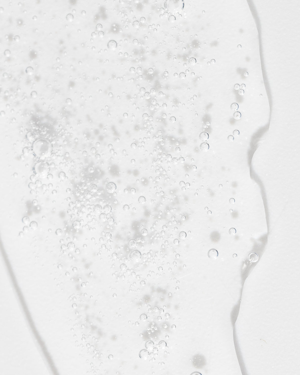Close-up of clear Refreshing Toner liquid with bubbles, highlighting its gentle, hydrating formula for cleansing and exfoliating skin.