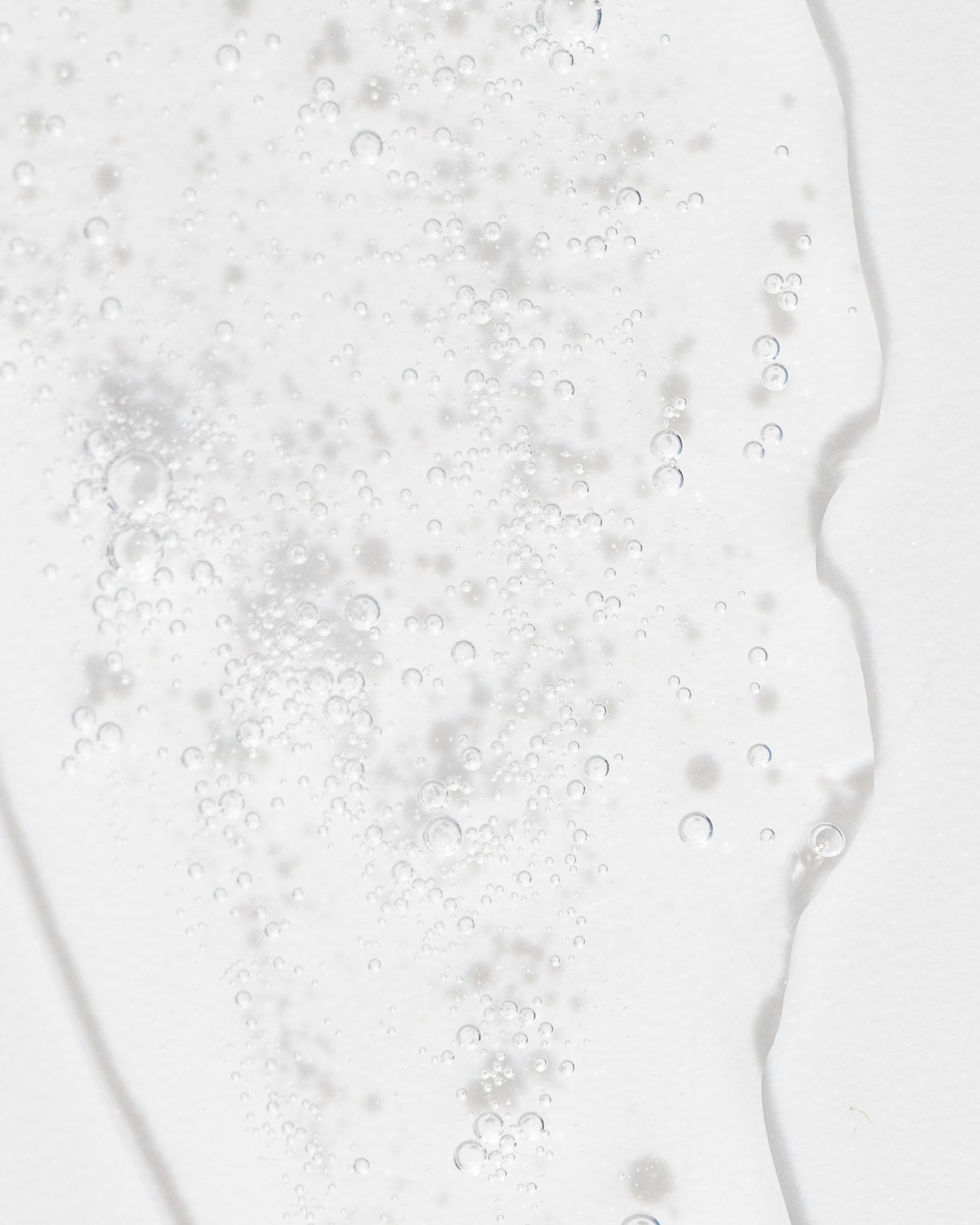 Close-up of clear Refreshing Toner liquid with bubbles, highlighting its gentle, hydrating formula for cleansing and exfoliating skin.