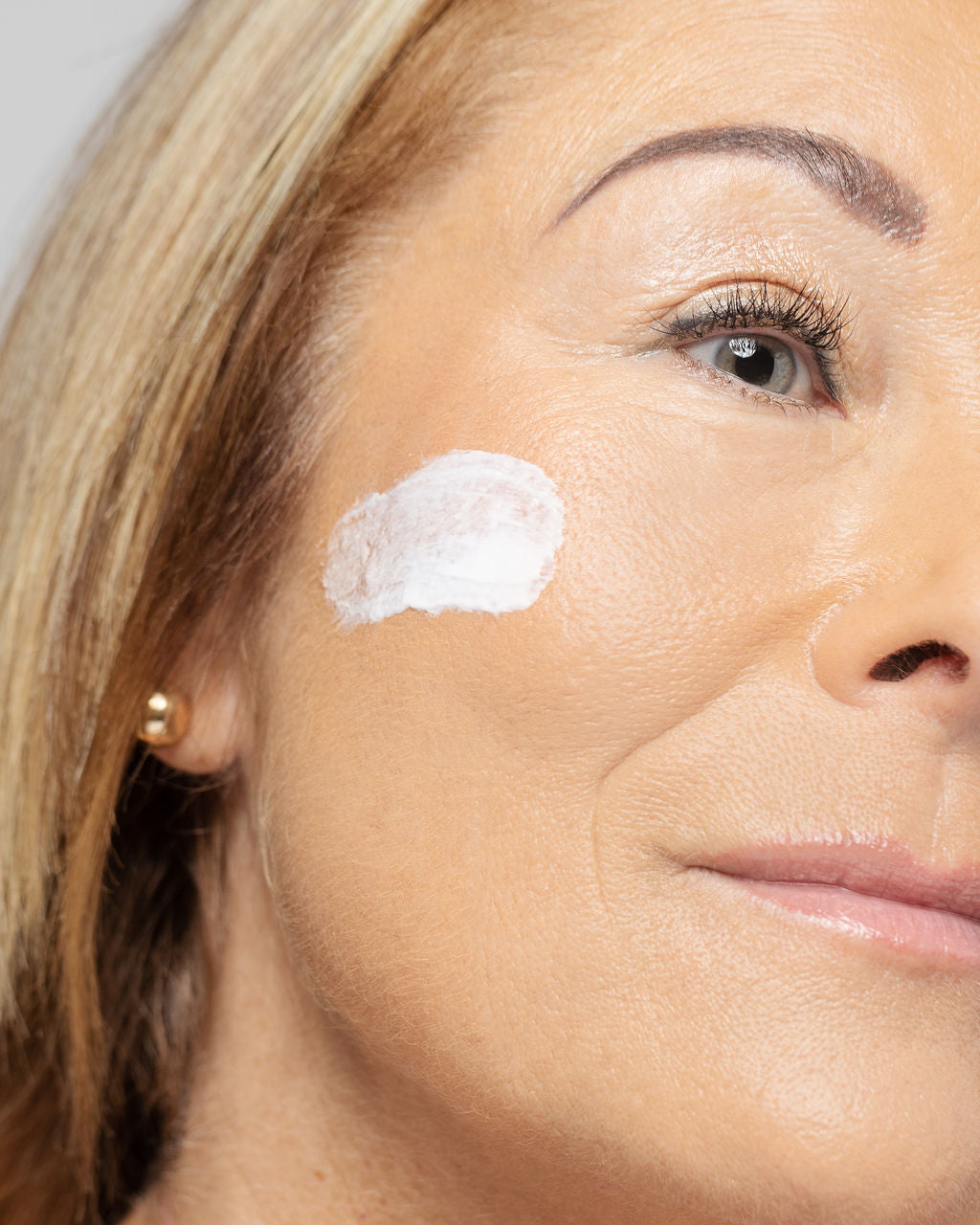 Woman applying Vivier Retinol 0.3% cream for improved skin texture and tone.