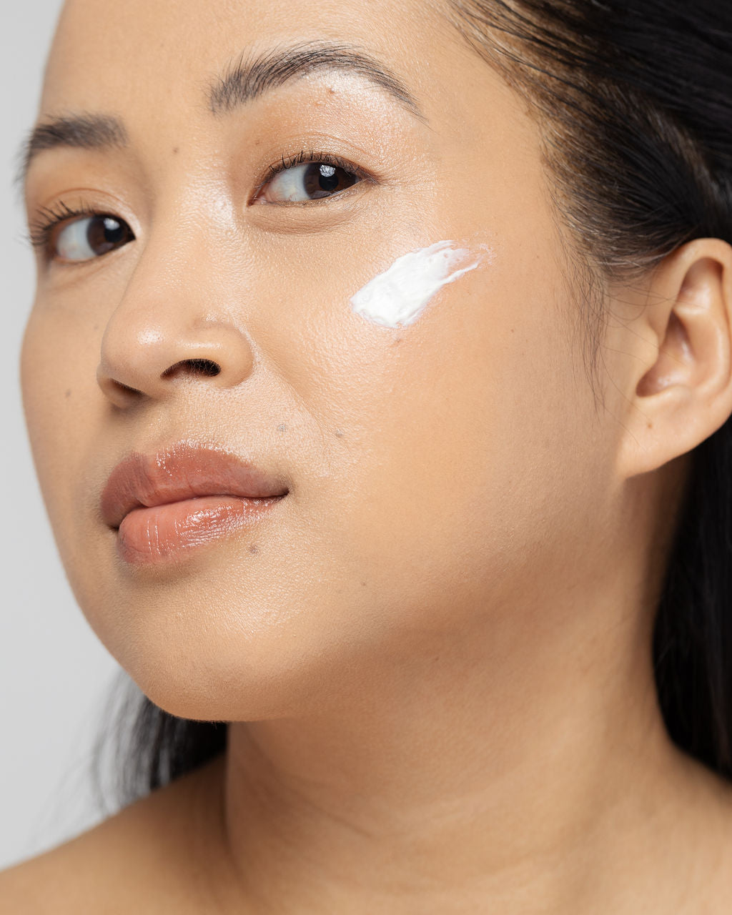Woman applying Vivier Retinol 0.5% cream to face for improved skin texture and reduced fine lines.