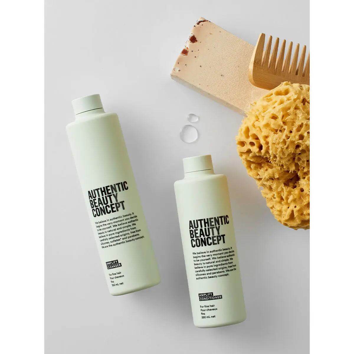 Authentic Beauty Concept Amplify Cleanser bottles with sponge and comb for volumizing fine hair, vegan and cruelty-free.