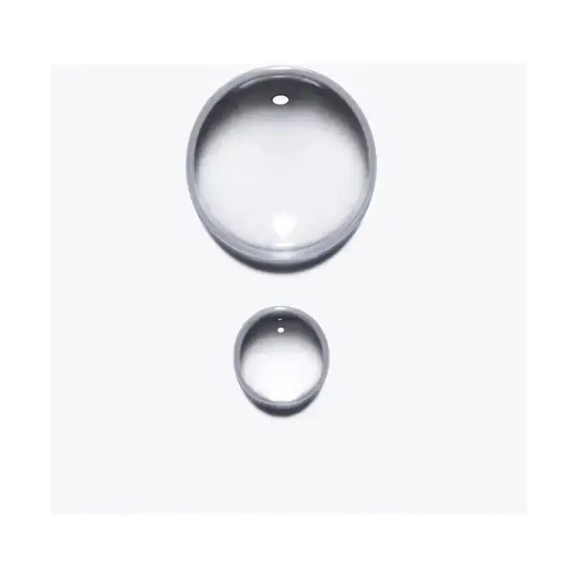 Close-up of two drops of Kérastase Anti-Breakage Fortifying Serum designed to strengthen damaged hair.