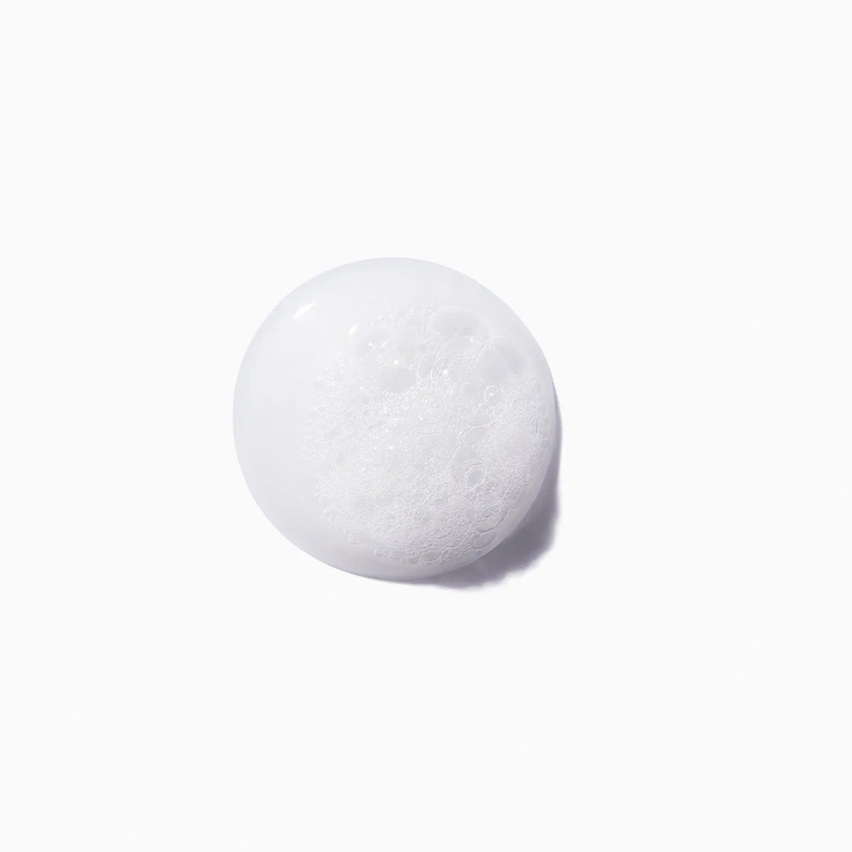 Close-up of Bain Force Architecte Shampoo foam texture on a white background, showcasing its restorative and strengthening properties.