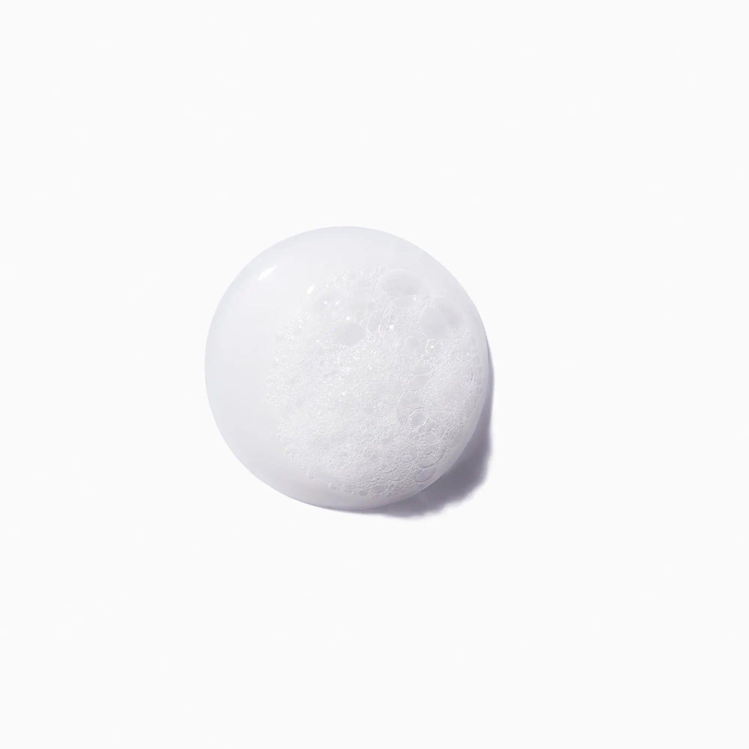 Close-up of Bain Force Architecte Shampoo foam texture on a white background, showcasing its restorative and strengthening properties.