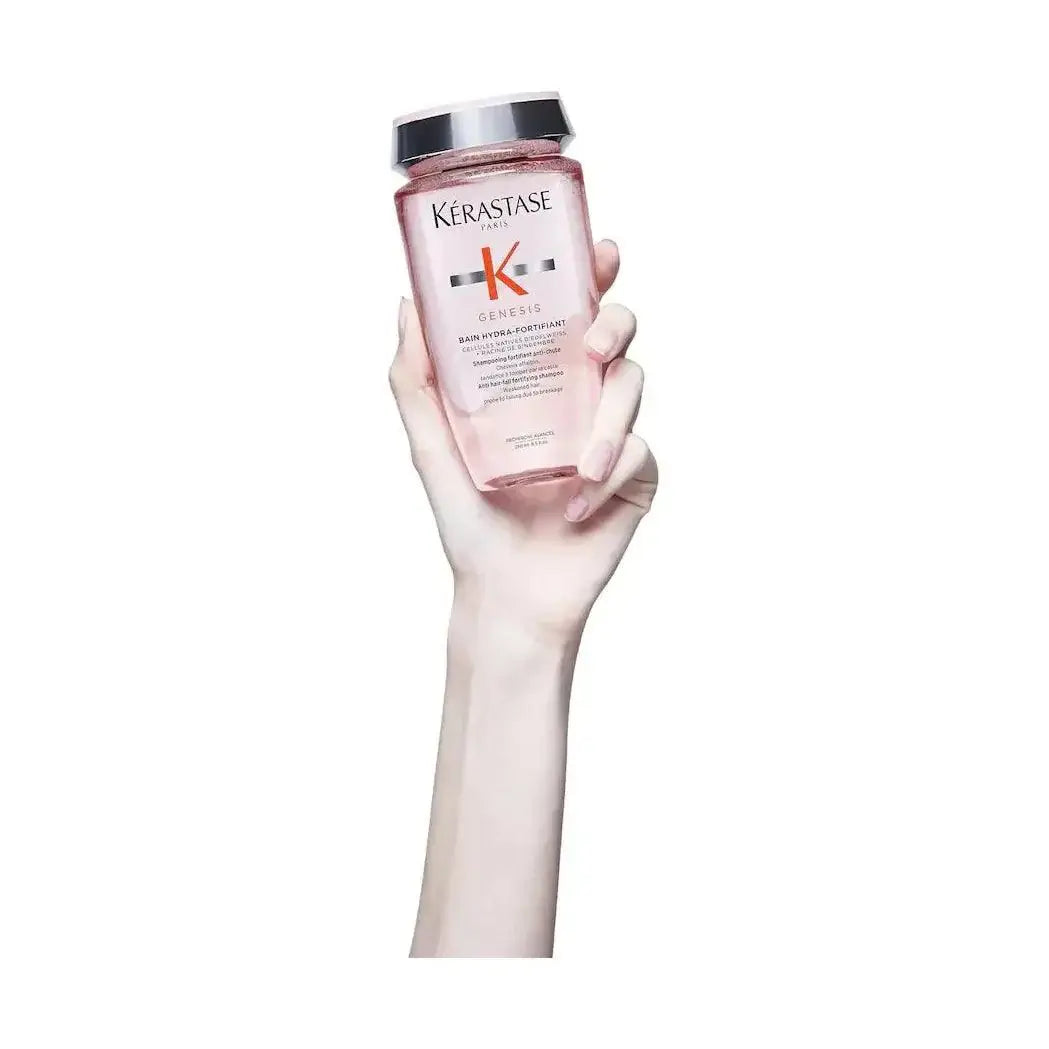 Kérastase Bain Hydra Fortifiant shampoo held in hand, fortifying and strengthening fragile hair, ideal for damaged hair concerns.