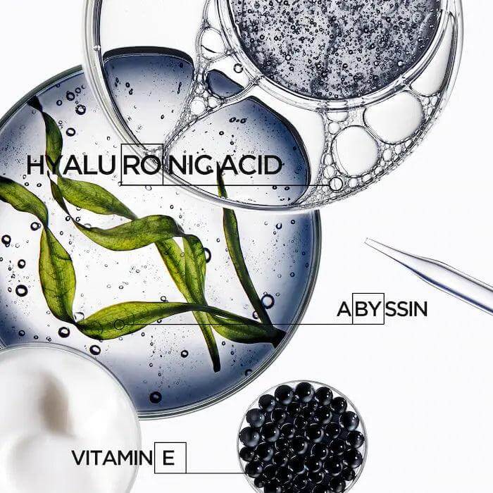 Skincare ingredients hyaluronic acid, vitamin E, and abyssine in Petri dishes with green leaf extract shown in a rejuvenating formula.