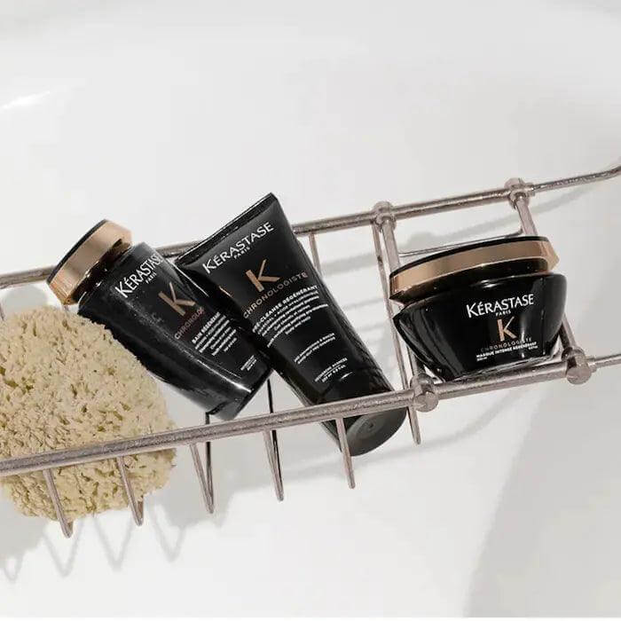 Kerastase Bain Régénérant shampoo and hair care products in a bathtub caddy for revitalizing dull hair.
