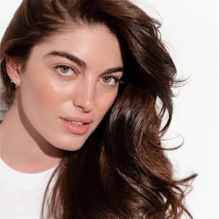 Woman with long, shiny hair showcasing the effects of rejuvenating shampoo for all hair types and textures.