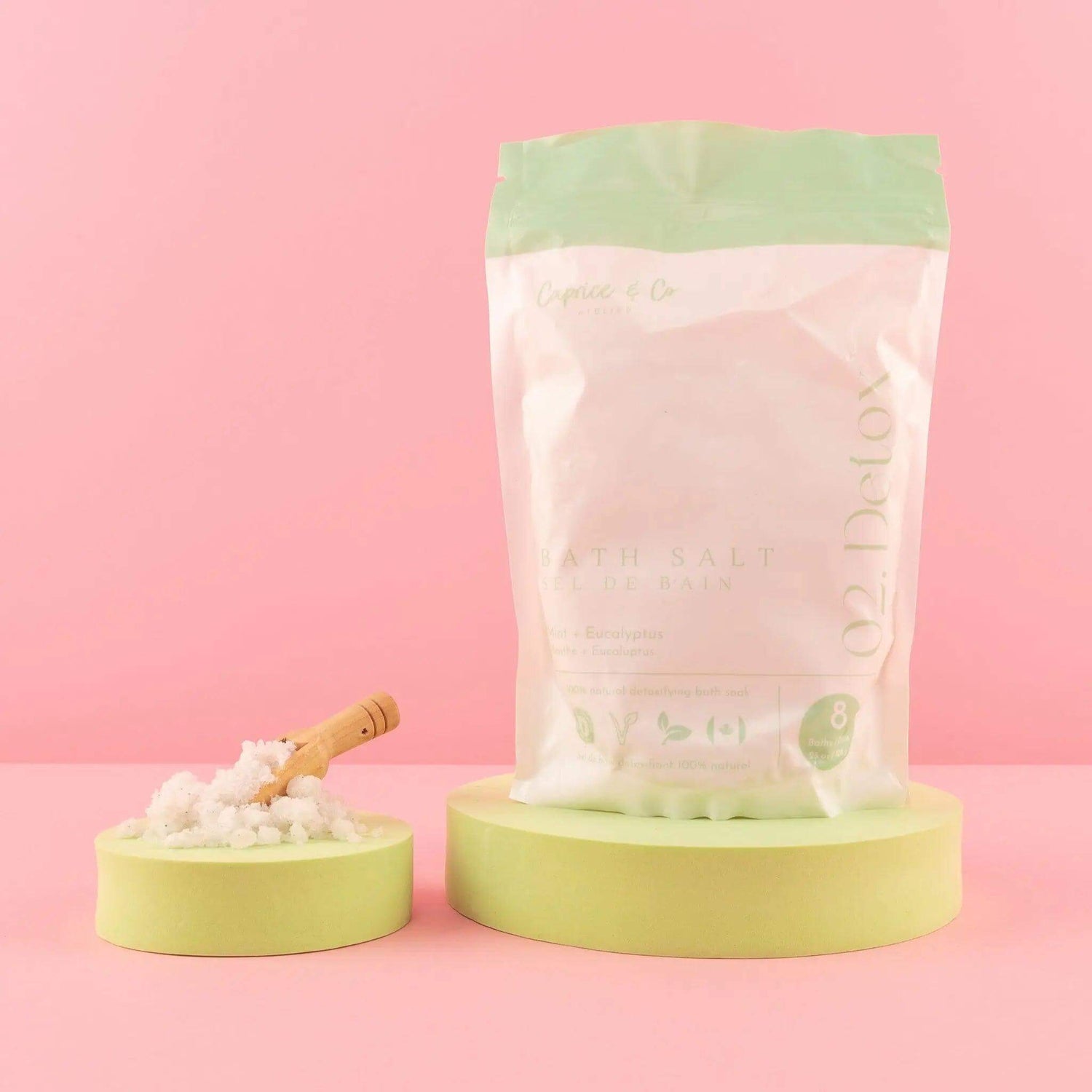 Bag of all-natural pink bath salts with a wooden scoop, featuring mineral-rich Himalayan and epsom salts on a pastel background.