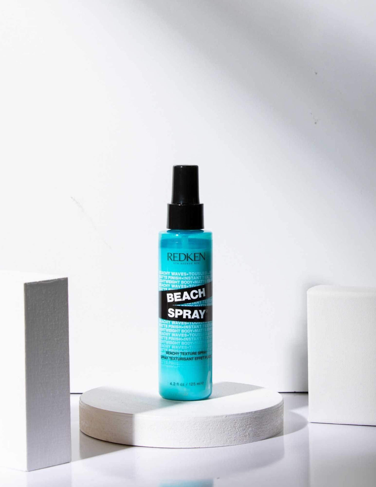 Redken Beach Spray bottle for texturizing hair in a ocean-inspired setting.