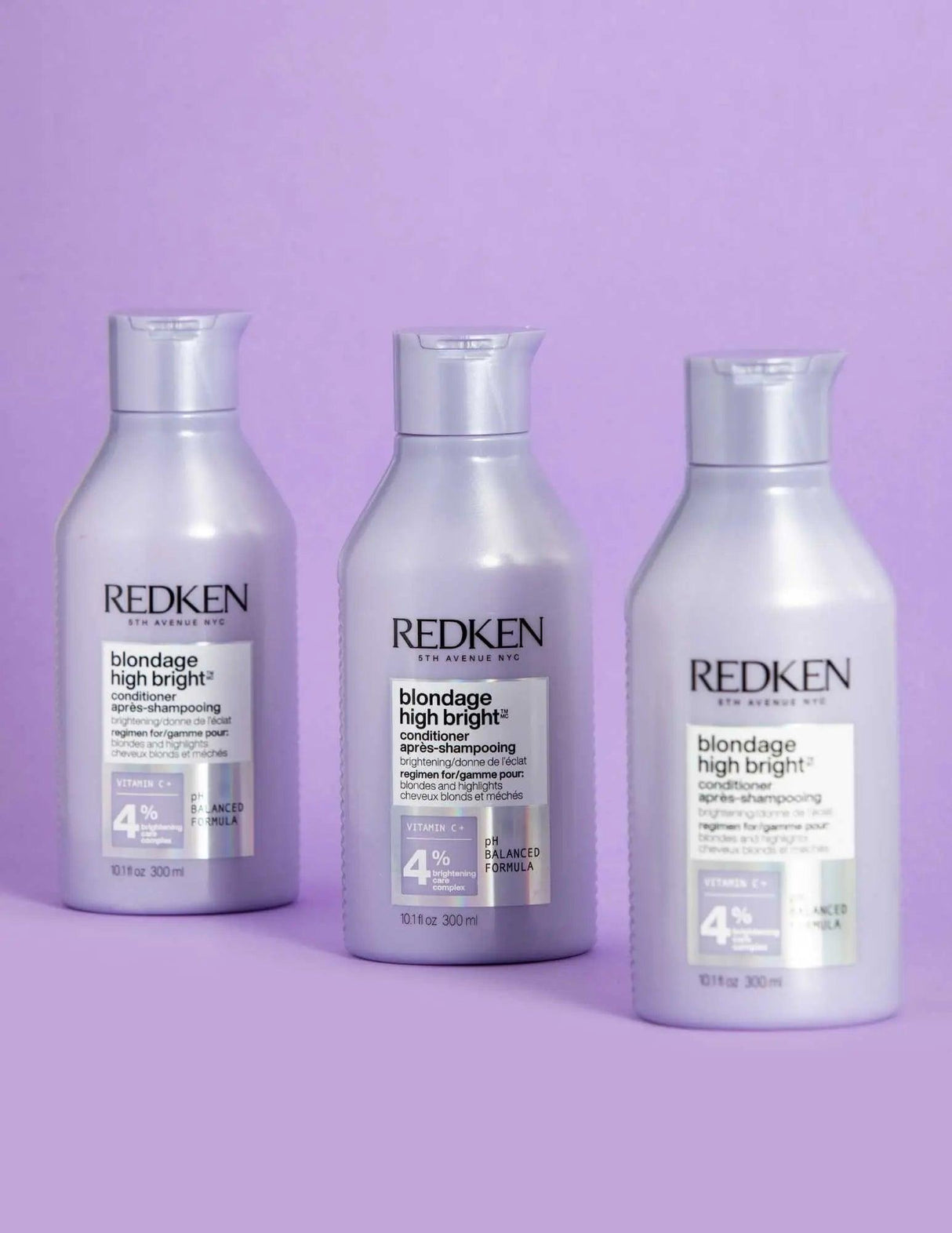 Redken Blondage High Bright Conditioner bottles for enhancing and preserving blonde hair brightness on a purple background.