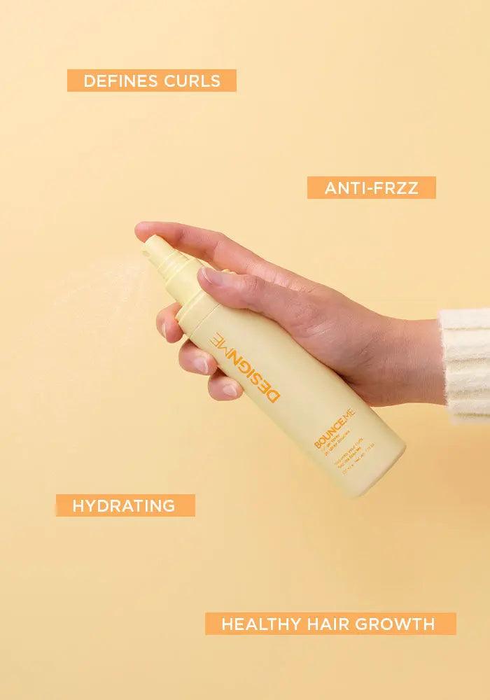 Hand holding a curl-enhancing spray bottle, with benefits labeled: defines curls, anti-frizz, hydrating, and healthy hair growth.