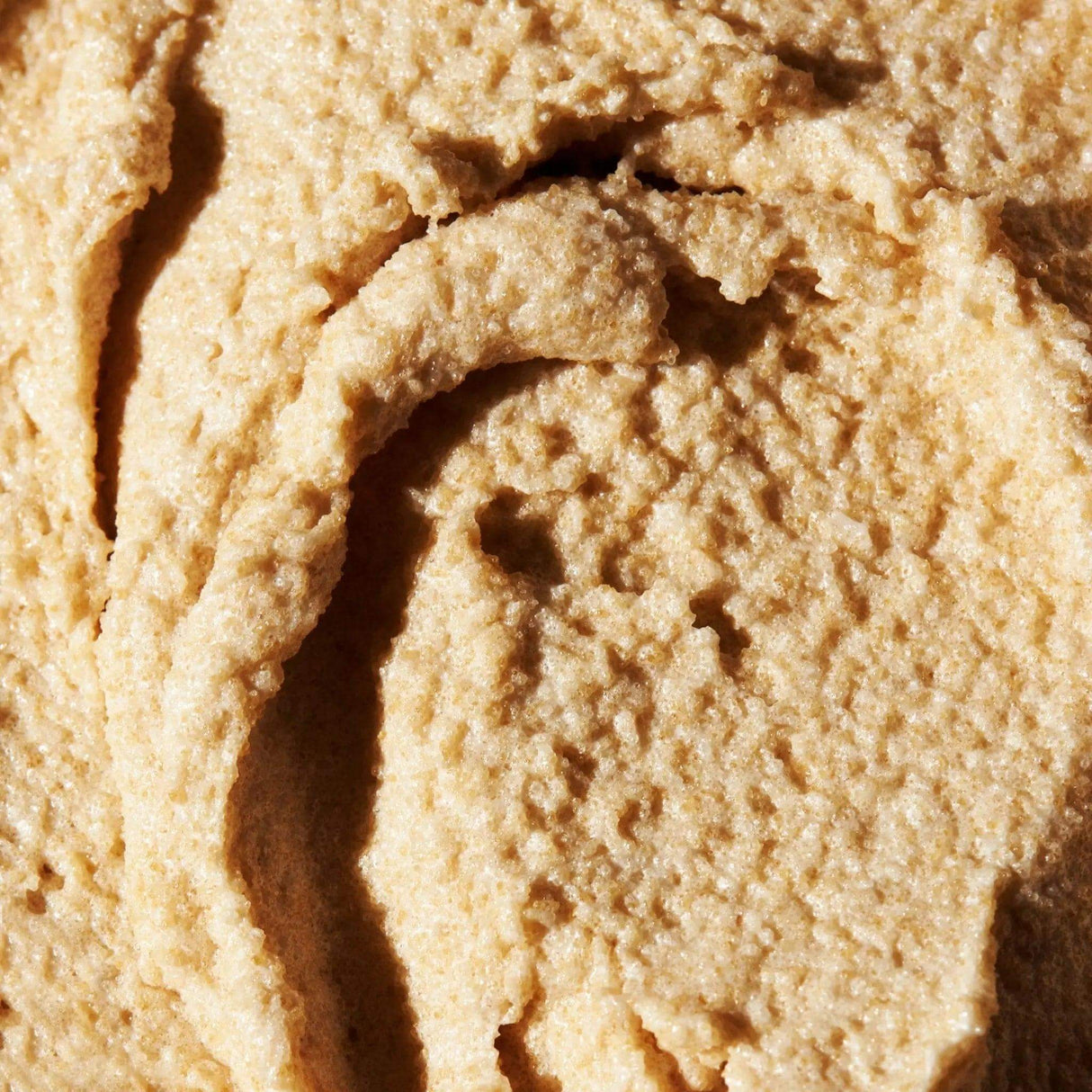 Close-up of Brown Sugar Vanilla Sugar Scrub texture, showcasing its natural exfoliant qualities for luminous skin and spa-like care.