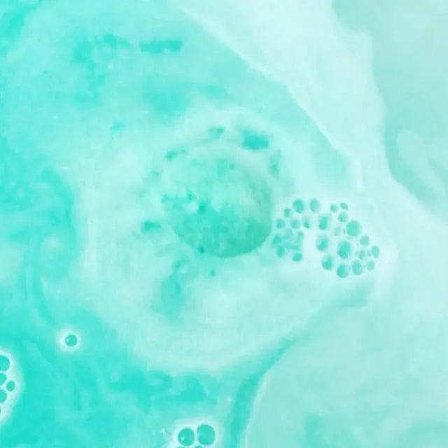 Calypso bath bomb dissolving in water, creating a swirl of aloe and cucumber fragrance with soothing bubbles.