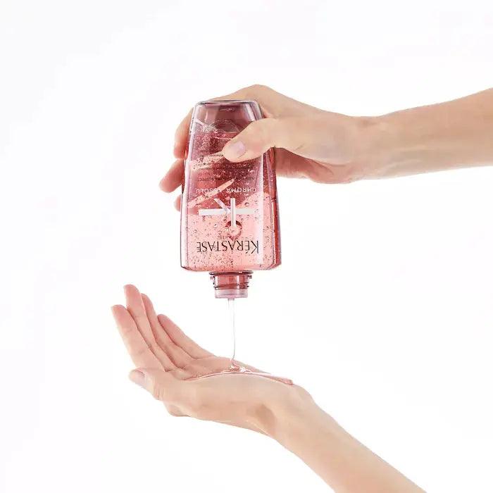 Pouring Kérastase Chroma Absolu sulfate-free shampoo for color-treated hair into hand, promoting vibrant, nourished hair care.