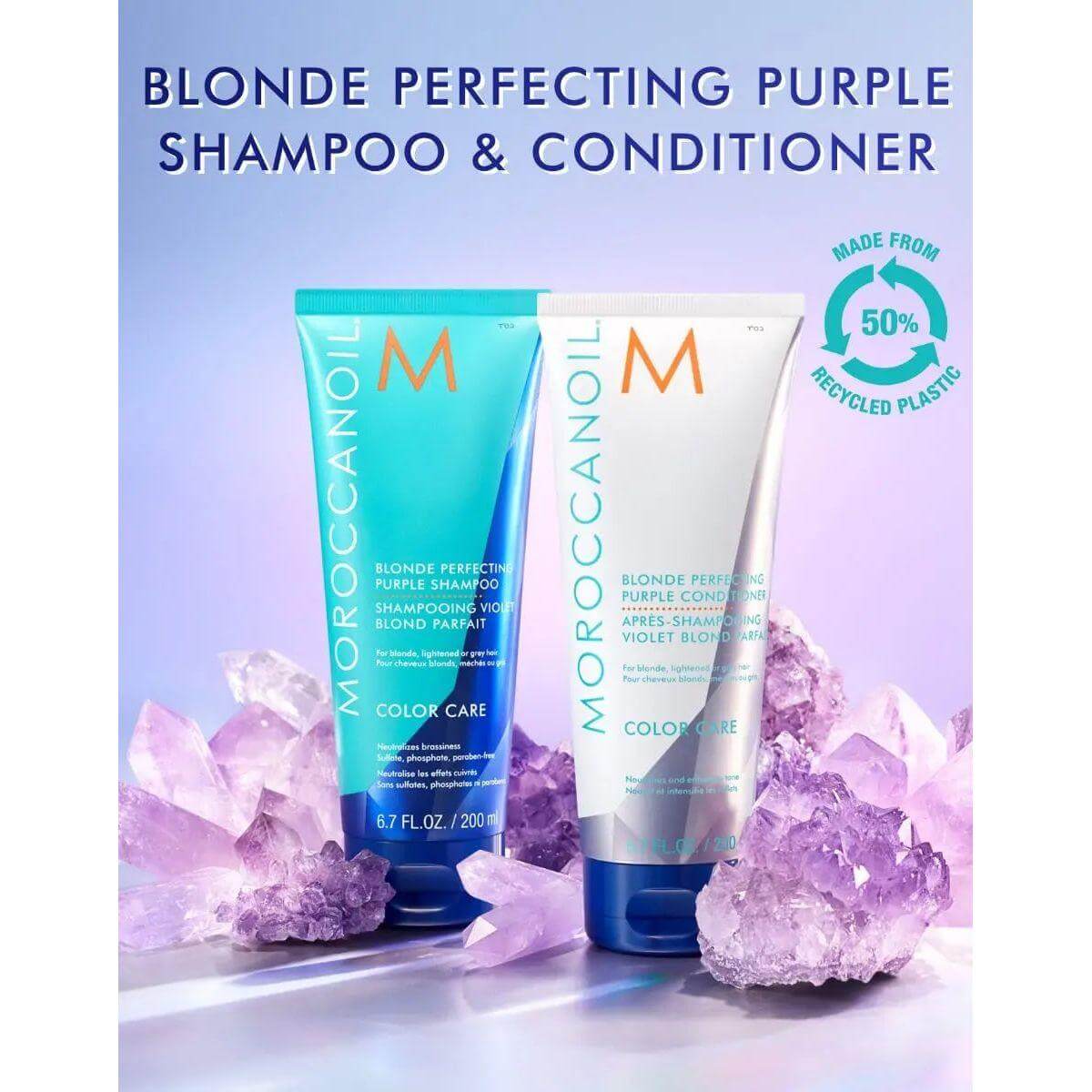 Moroccanoil Blonde Perfecting Purple Shampoo & Conditioner with recycled plastic packaging, surrounded by purple crystals.
