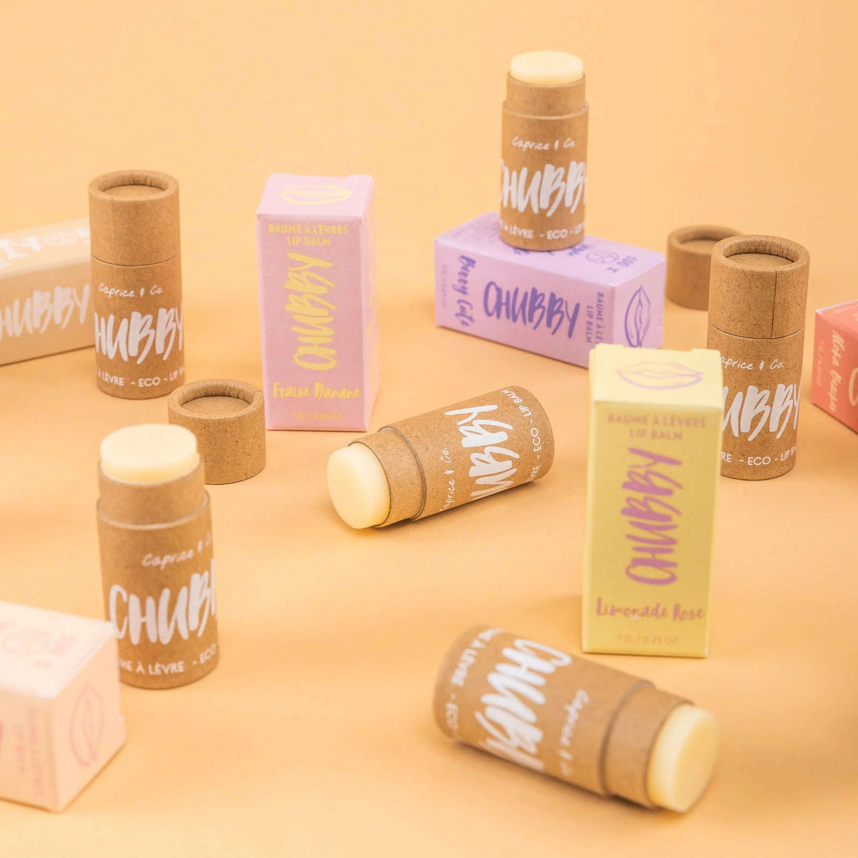 Eco-friendly and vegan lip balm in compostable packaging with various flavors on a pastel background. 100% natural and organic ingredients.