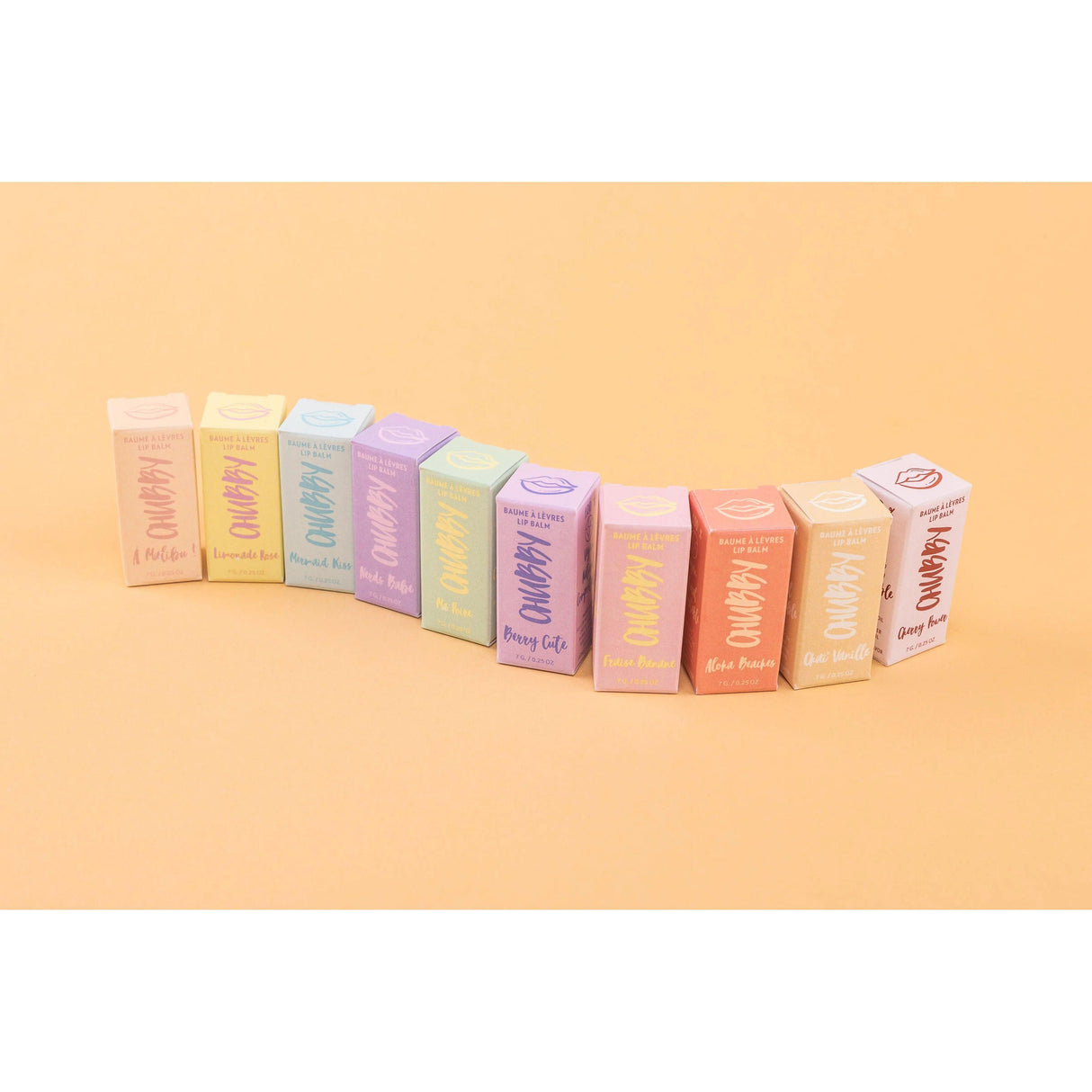 Colorful packaging of compostable vegan lip balms on a peach background. Eco-friendly, natural, and plastic-free skincare.