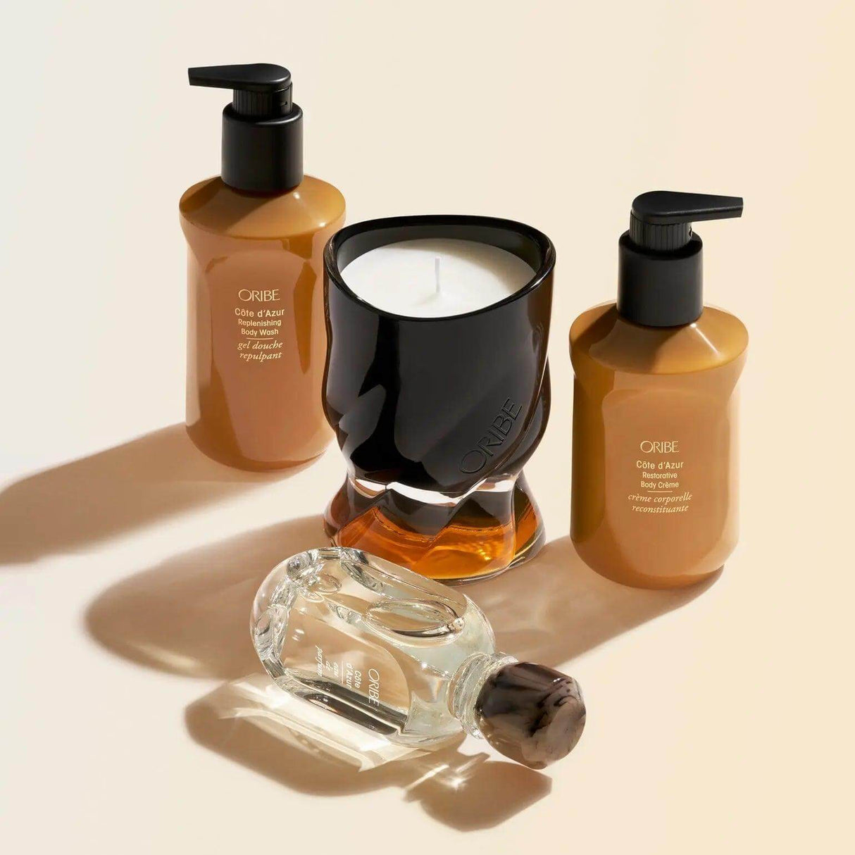 Oribe Côte d'Azur Restorative Body Crème and candle set showcasing luxury body care products with elegant design.