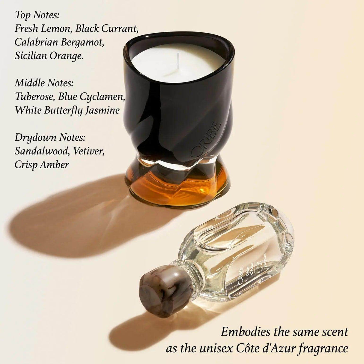 Côte d'Azur scented candle by Oribe with fragrance notes of lemon, bergamot, orange, and sandalwood, next to matching fragrance.