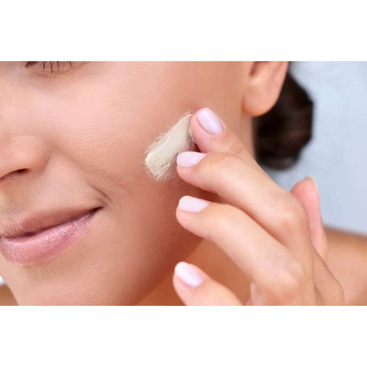 Woman applying Crème Nuit to face for moisturizing and brightening effect with Swiss Alpine Extracts and Retinol.