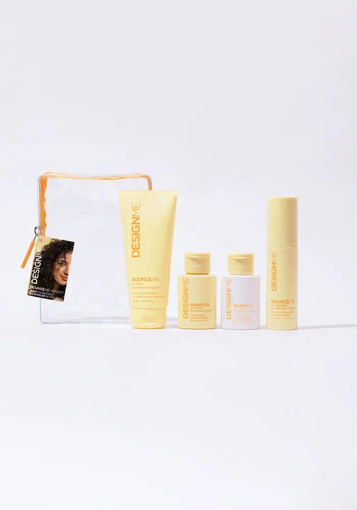 Curl Discovery Kit with shampoo, conditioner, curl balm, and spray gel for bouncy curls, in front of a clear travel bag.