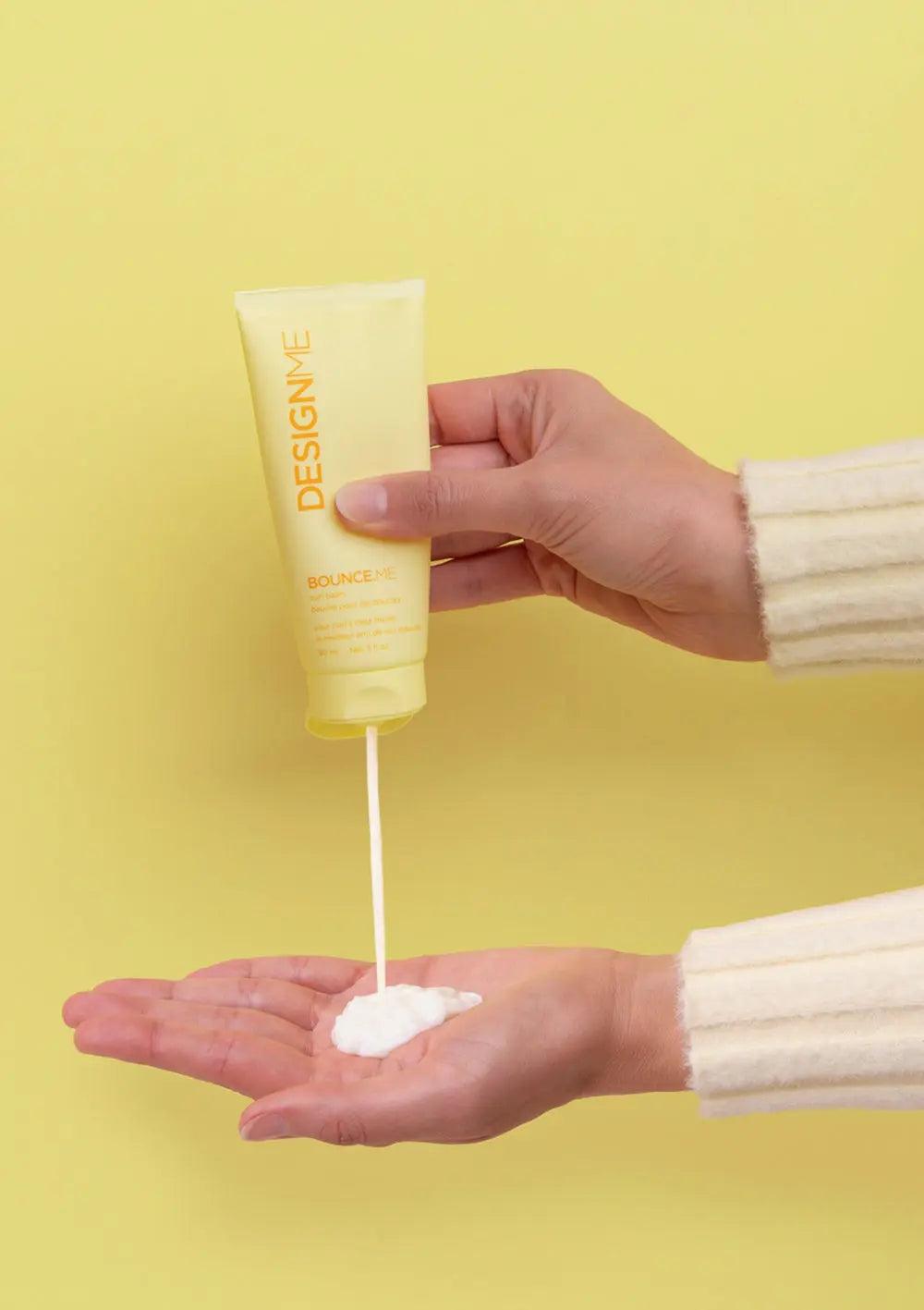 Applying DESIGN.ME BOUNCE.ME curl balm from the Curl Discovery Kit to hands for defined, bouncy curls.