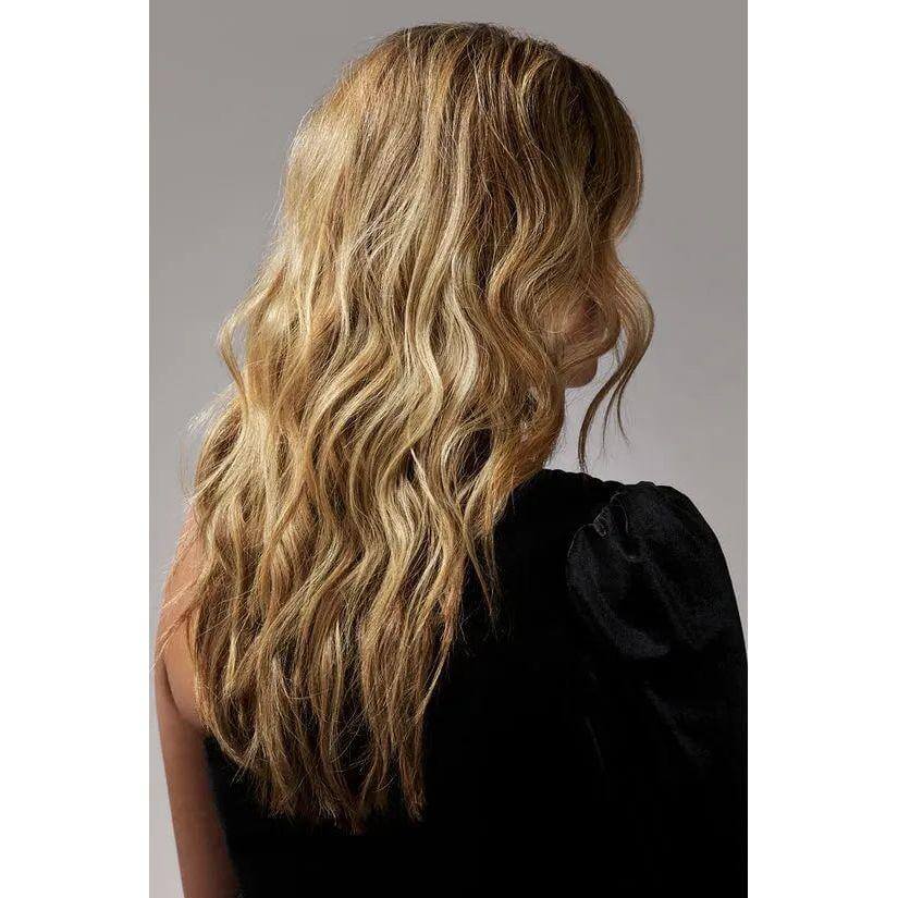 Woman with voluminous wavy hair styled using dry texturizing spray, showcasing hair volume and smoothness.