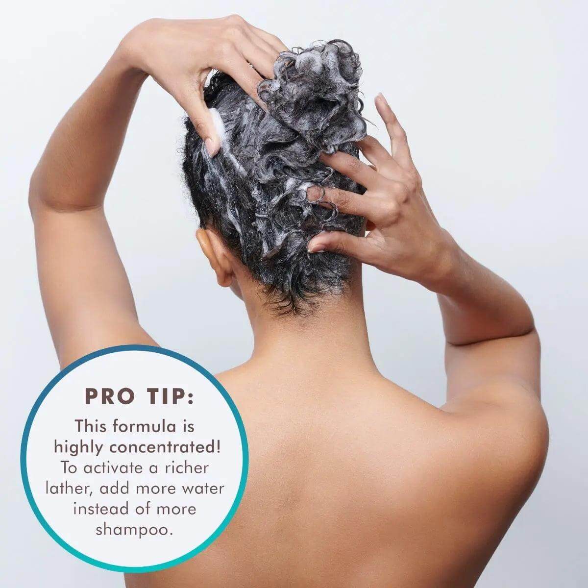 Person applying Moroccanoil Extra Volume Shampoo, highlighting rich lather technique with pro tip on product concentration and use.