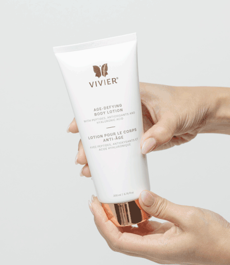 Vivier Age-Defying Body Lotion with peptides shown in hands, ideal for firming and toning skin while hydrating.