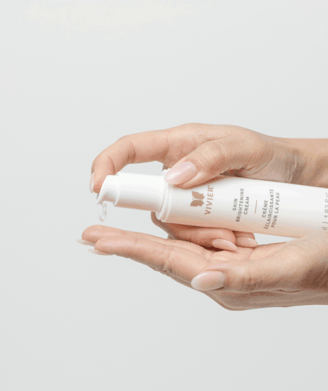 Hands applying Vivier Skin Brightening Cream for mild pigmentation and uneven skin tone treatment.