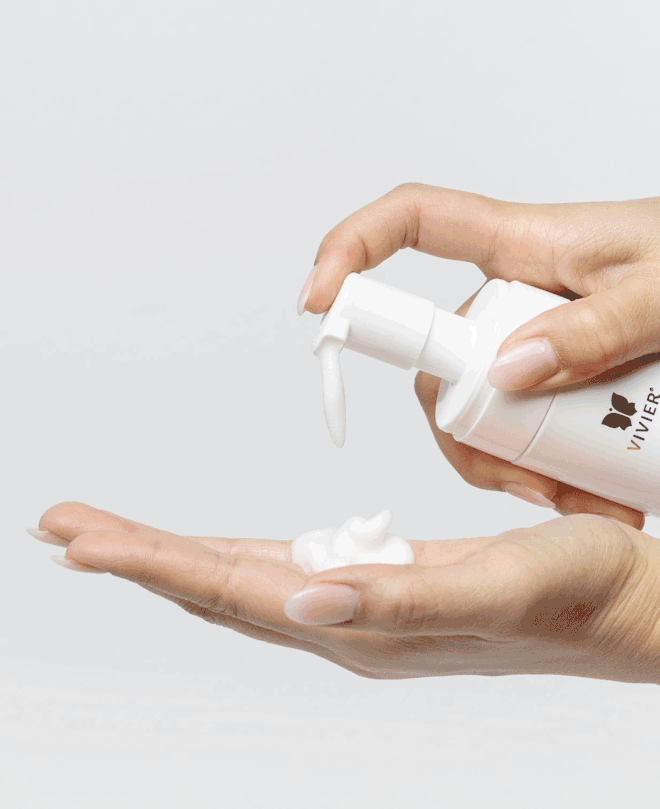 Applying Vivier Ultra Foaming Cleanser to hands, rich in Vitamin C and Glycerin for hydrated, revitalized skin.