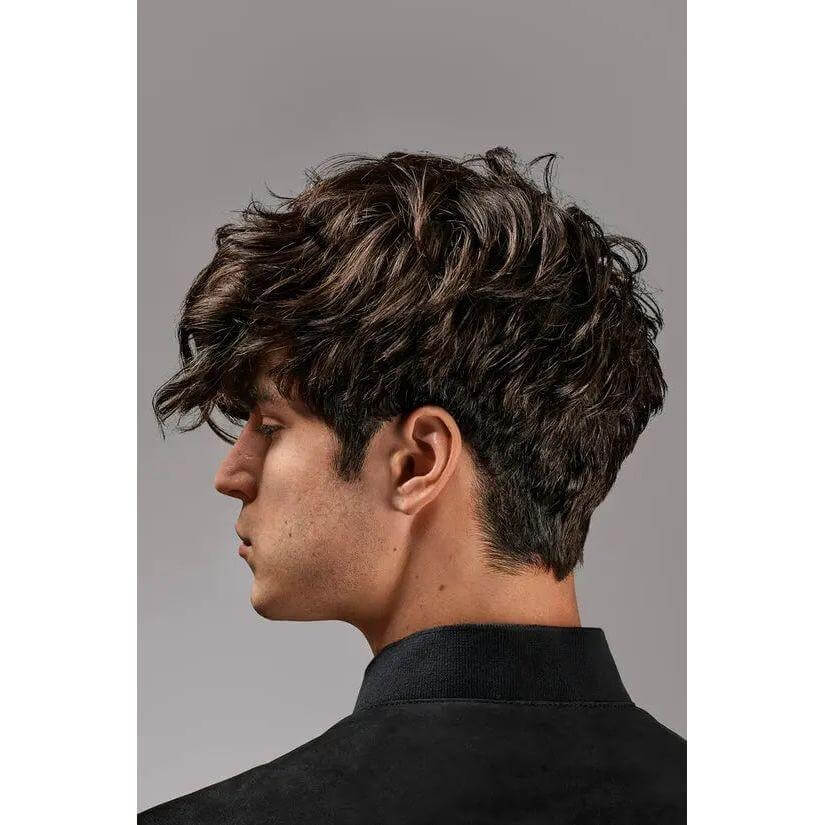 Side view of a man with styled, layered hair showcasing volume and texture.