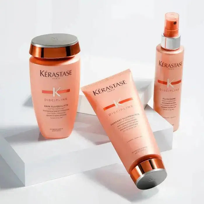 Kerastase Discipline hair care products including shampoo, conditioner, and frizz control spray on display.